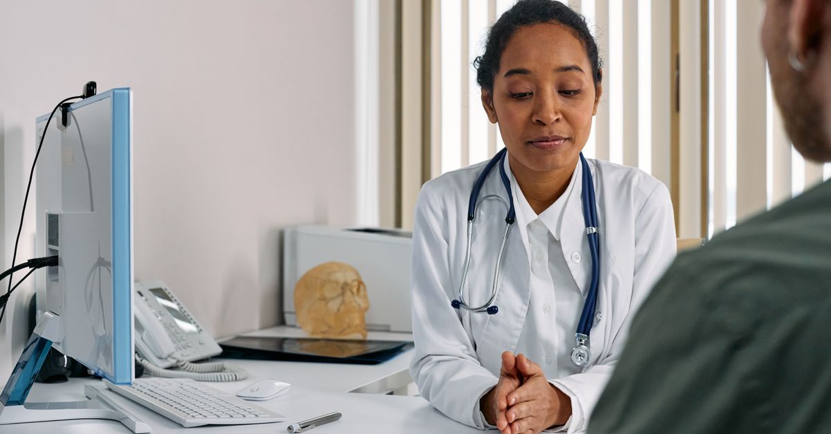 Médico em consultório moderno analisando fotos de procedimento em tablet