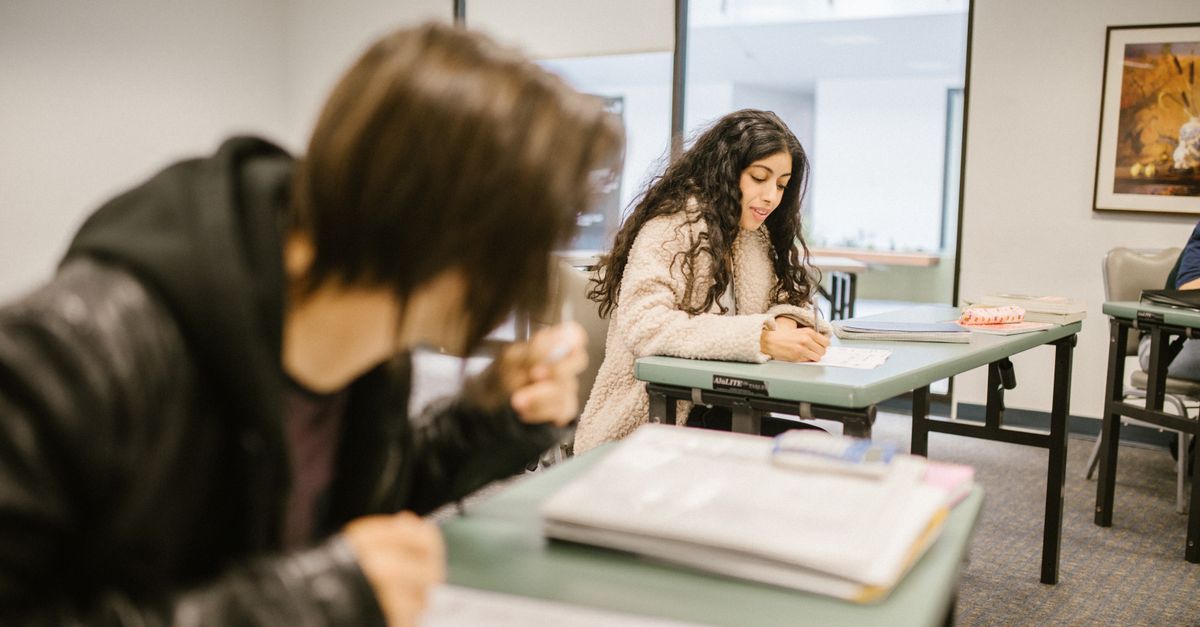 Estudantes fazendo prova em sala de aula