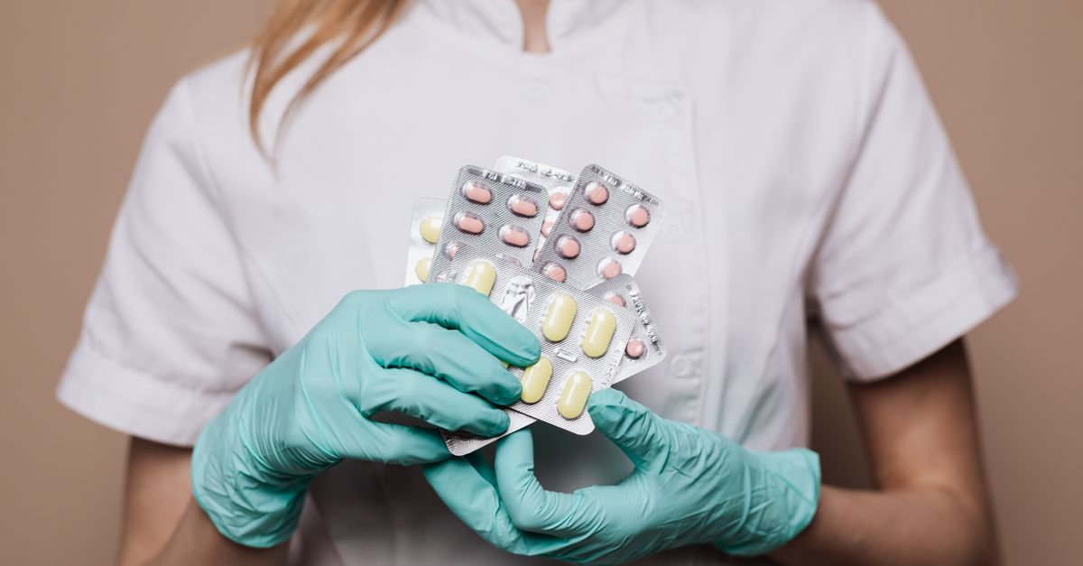 médico verificando interação medicamentosa em tablet durante consulta