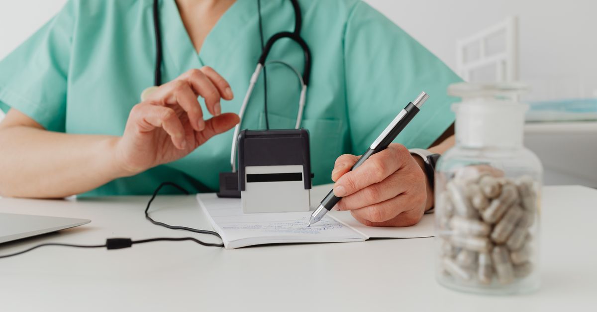Médico segurando prescrição médica com passaporte e medicamentos sobre mesa, preparando viagem internacional
