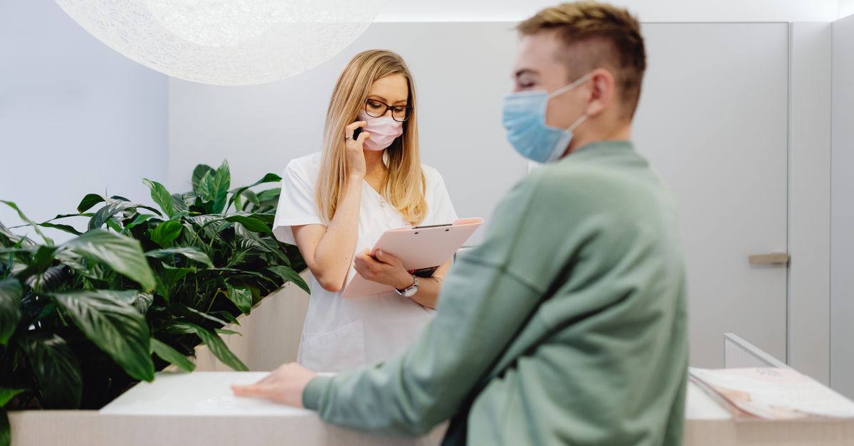 Recepção de consultório médico com computador e agenda na mesa